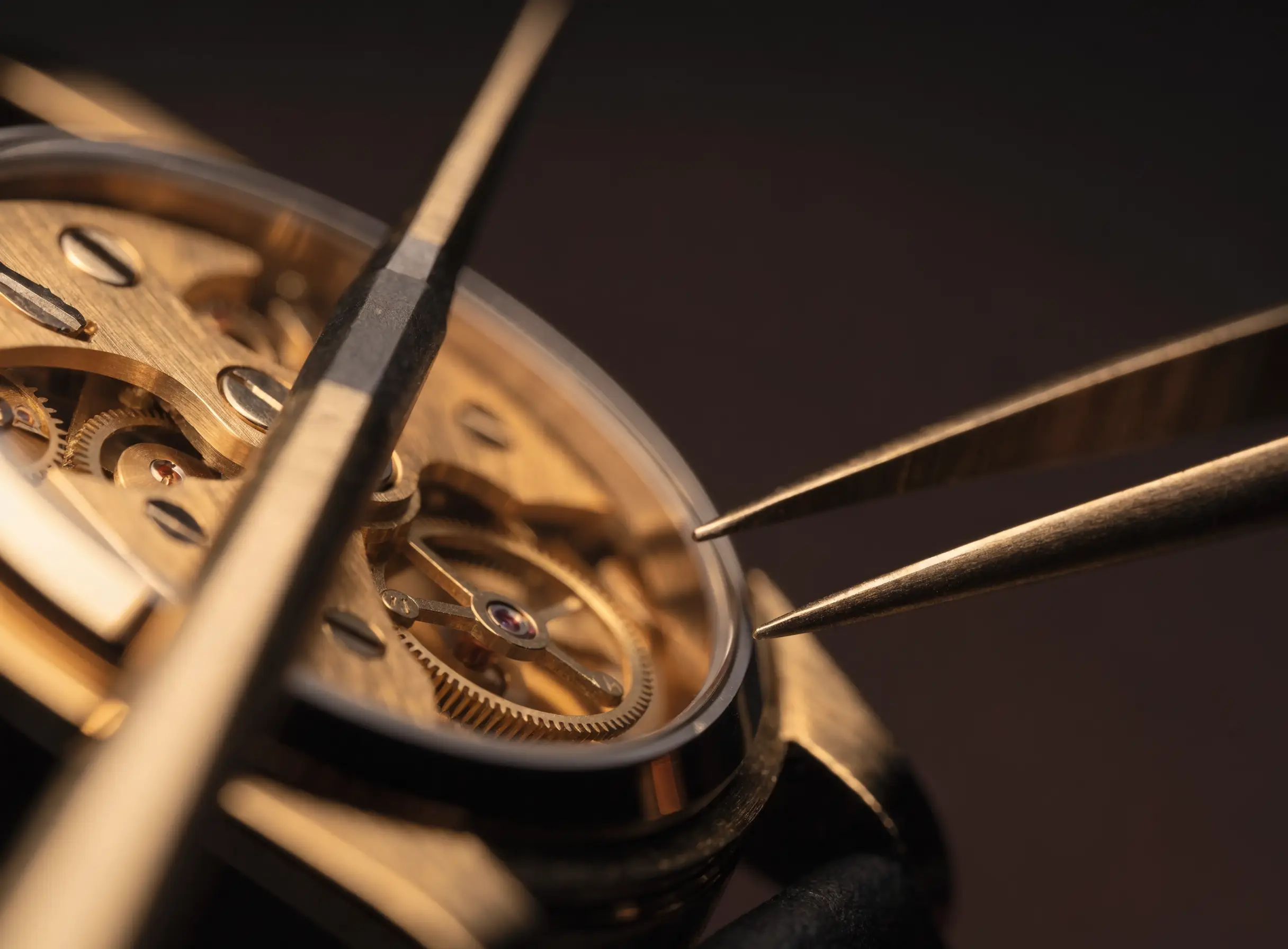A fine mechanical watch movement beside watchmaker’s tools